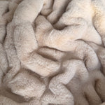 Close up of a faux fur beige blanket.