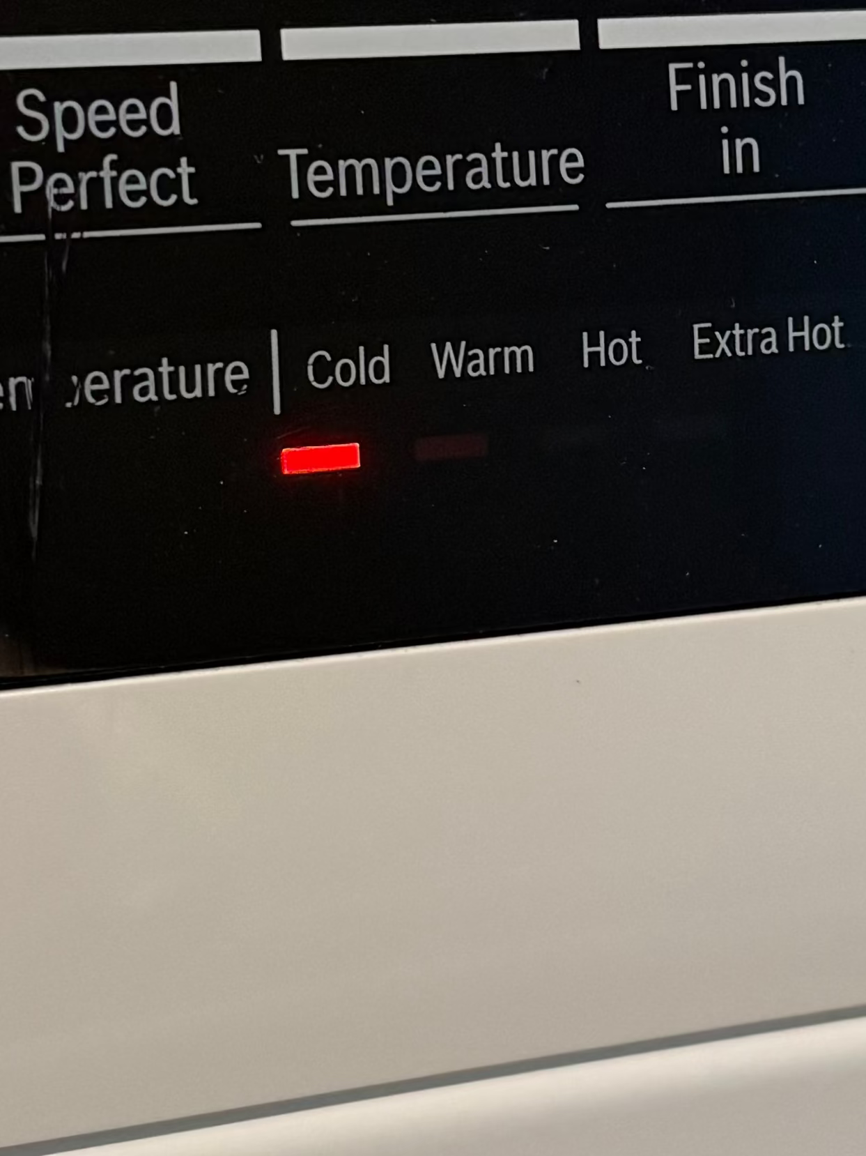 Washing machine control panel with digital display showing time and settings.