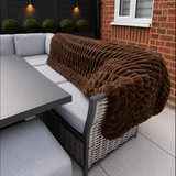 Brown blanket draped over outdoor sofa.
