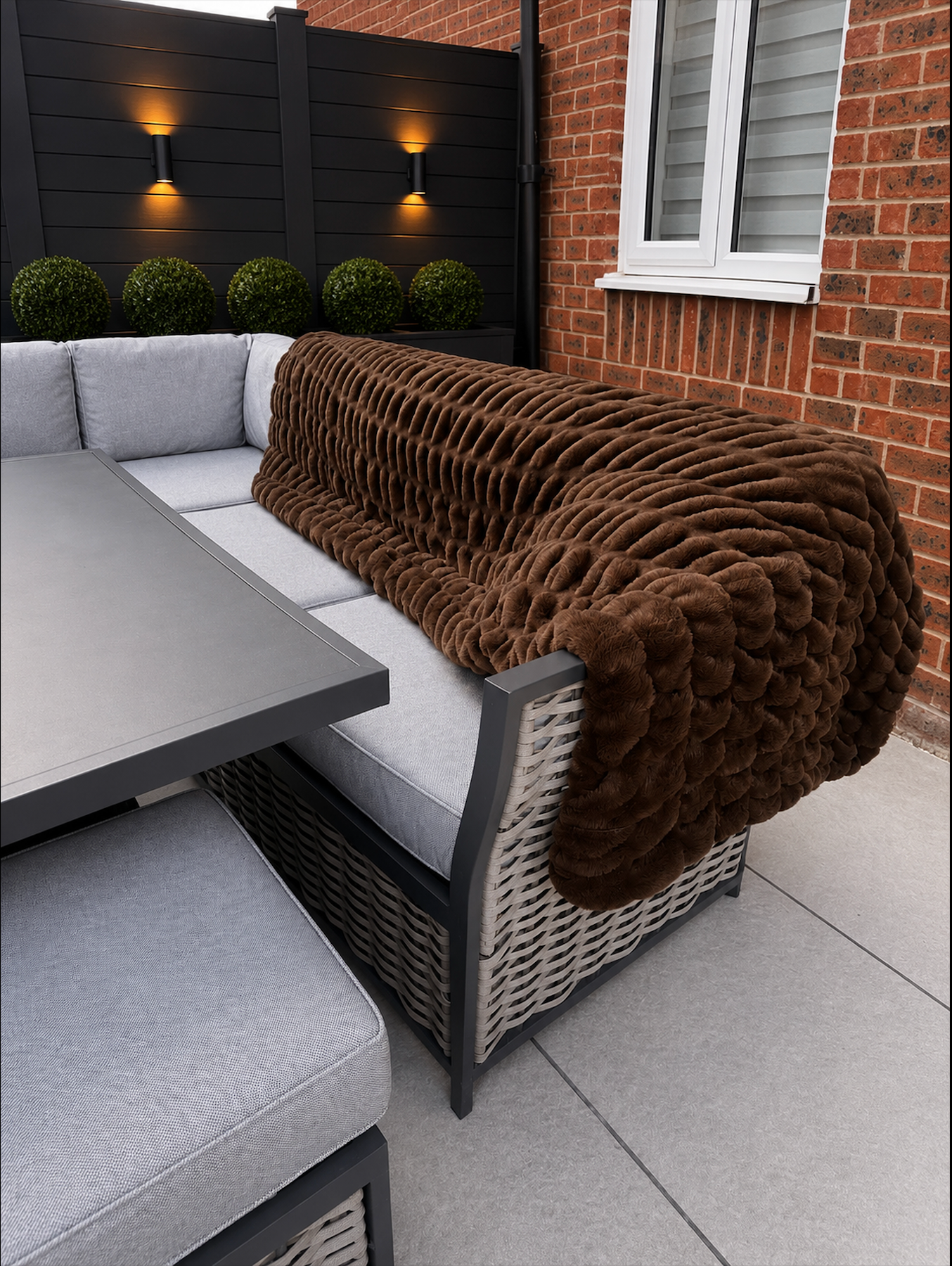 Brown blanket draped over outdoor sofa.
